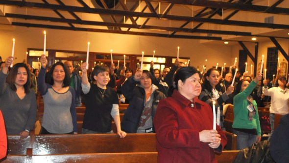 Filipino Americans light candles to express solidarity with the campaign to push for TPS designation for the Philippines during the forum at the Ascension Church in Queens.   Photo by NOEL T. PANGILINAN